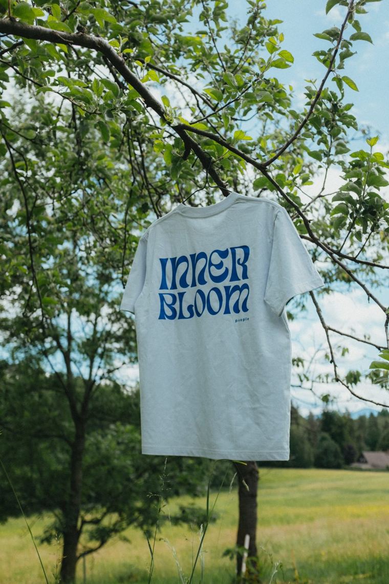 Tričko Inner Bloom pověšené na větvi jabloně
